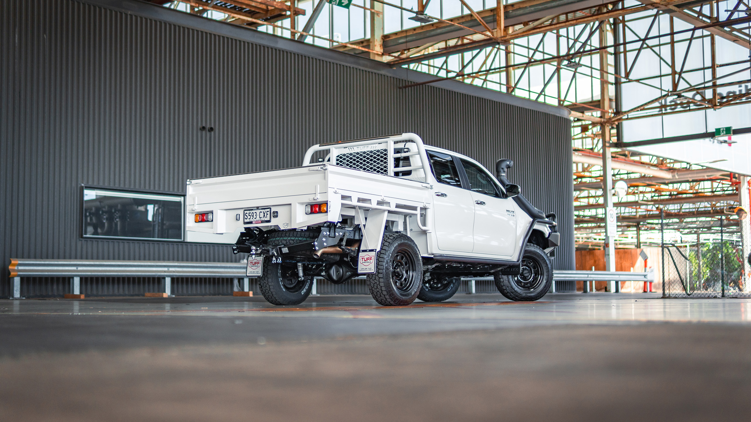 Ranger AT steel wheels on white Toyota HiLux inside industrial building Ranger AT steel wheels on white Toyota HiLux inside industrial building