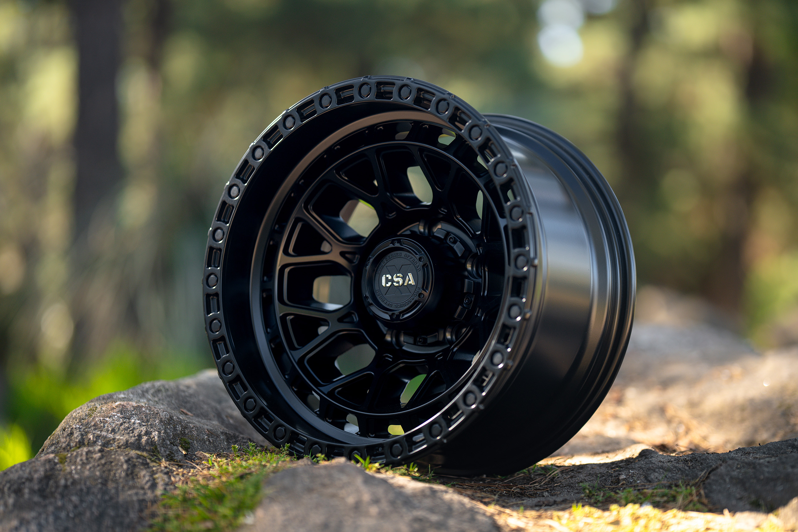 CSA Thunder Deep Dish Satin Black wheel on rocks in forest