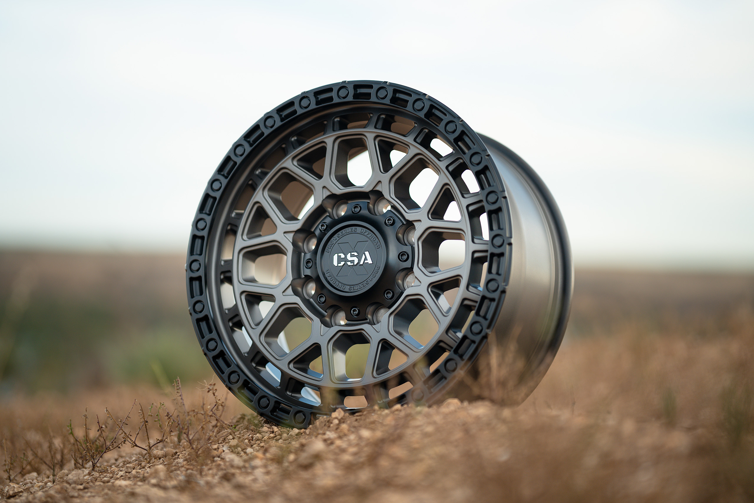 CSA Thunder HD Satin Graphite Black lip wheel on rocky outcrop