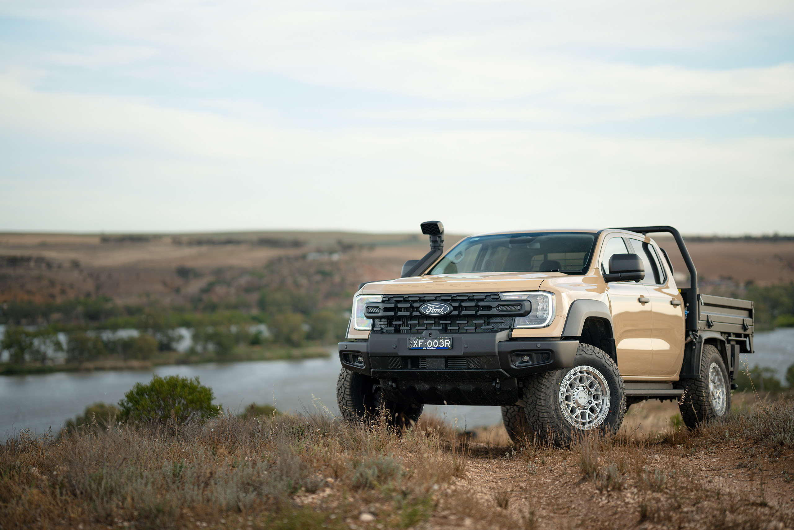 CSA Thunder HD machined wheels on Ford Ranger Super-Duty on gravel road at the top of a hill with scenic view overlooking a river