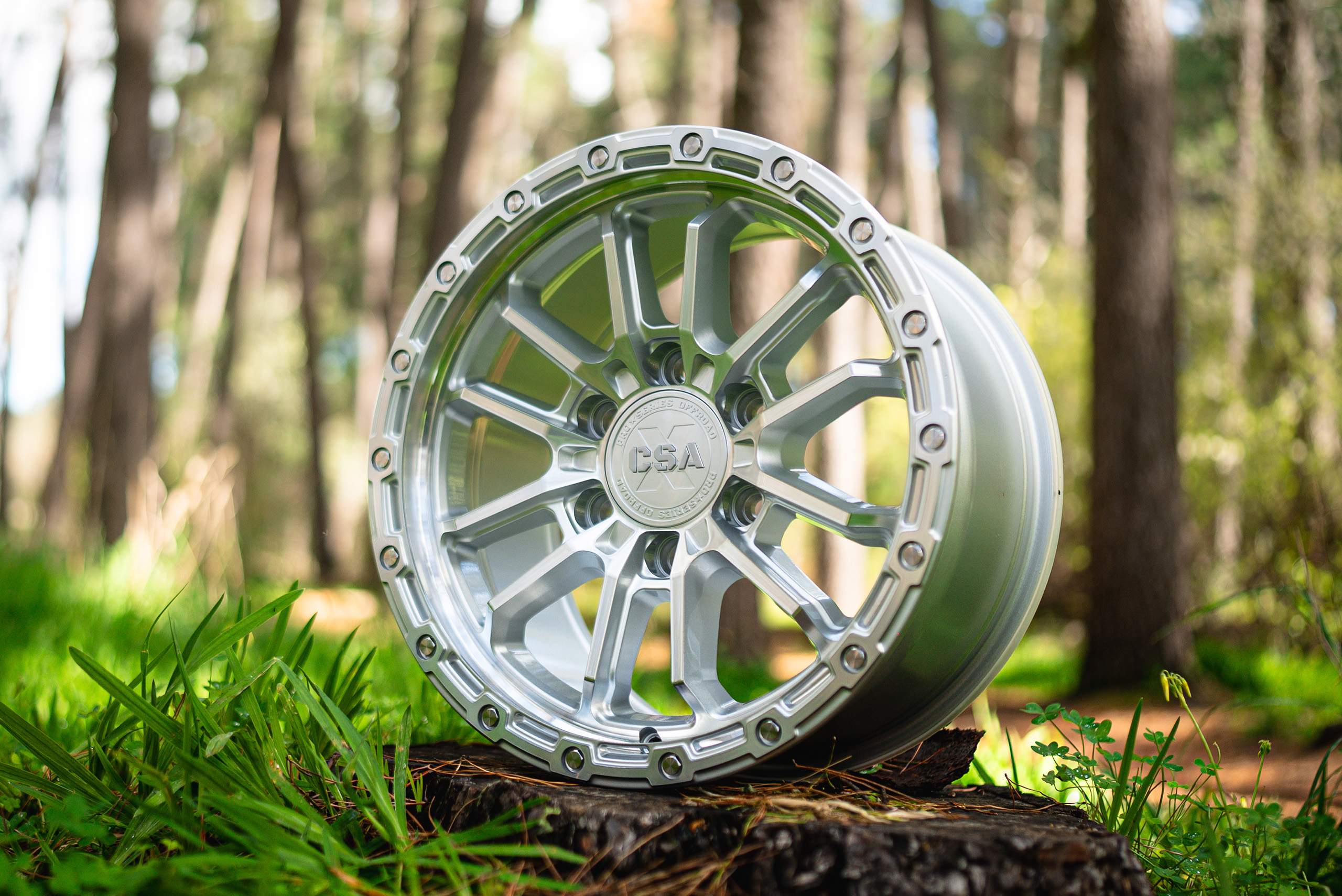 CSA Thor full machined wheel close up view on log in the green forest CSA Thor full machined wheel close up view on log in the green forest