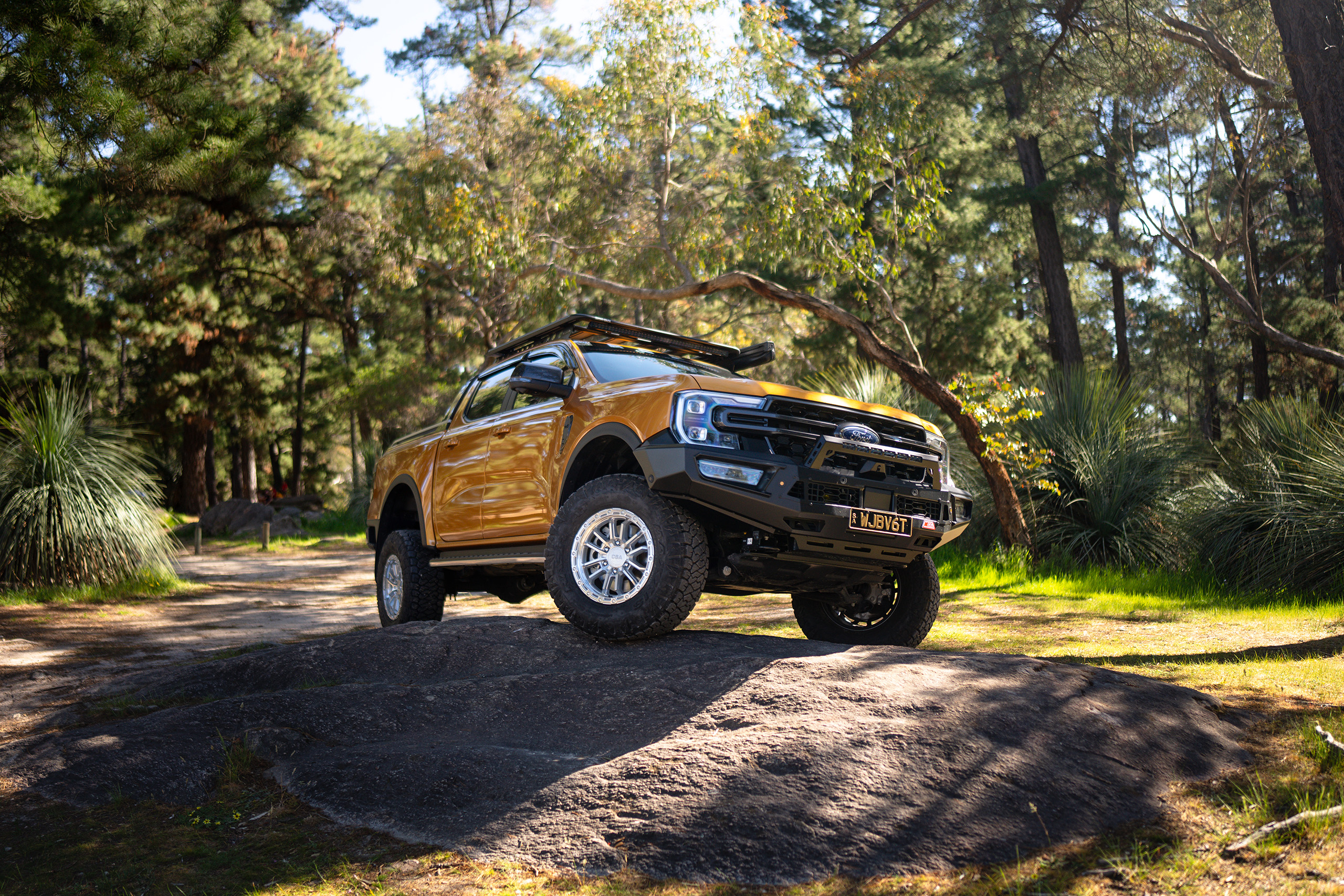 CSA Thor full machined wheel on gold Ford Ranger perched on a rock in the forest CSA Thor full machined wheel on gold Ford Ranger perched on a rock in the forest