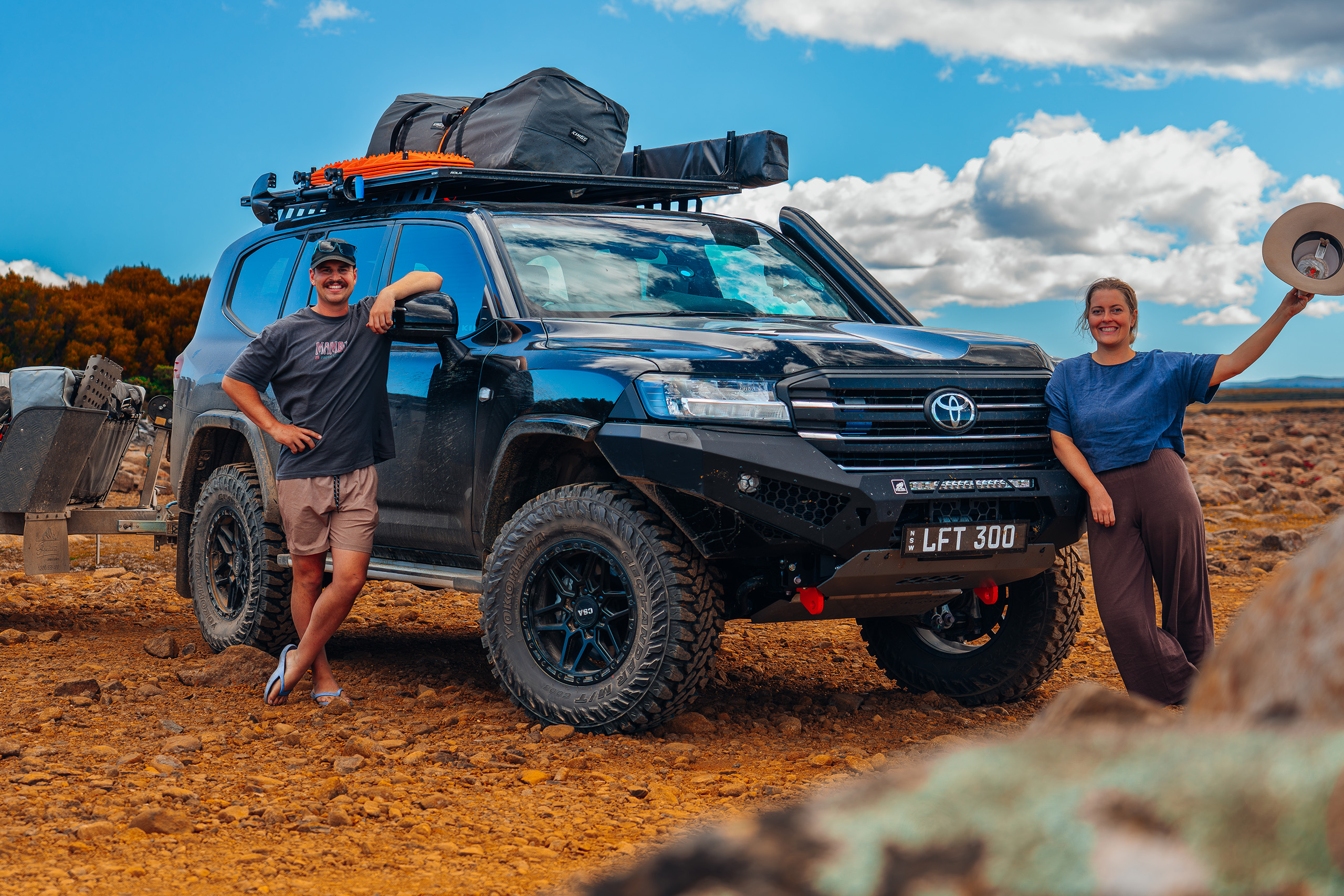 Sam and Maddy in front of their 300 Series LandCruiser with CSA Traction wheels on red dirt road