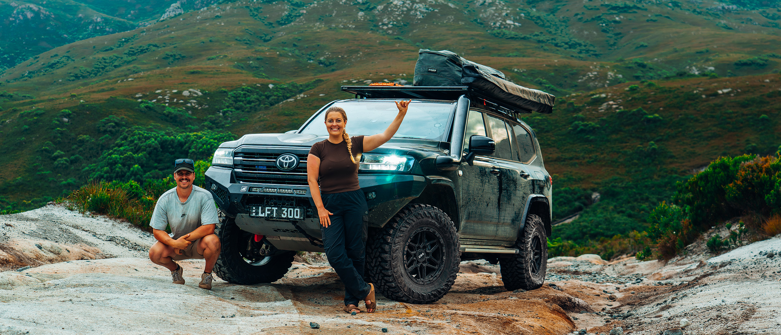 Sam and Maddy in front of their 300 Series LandCruiser with CSA Traction wheels on track in bush hills